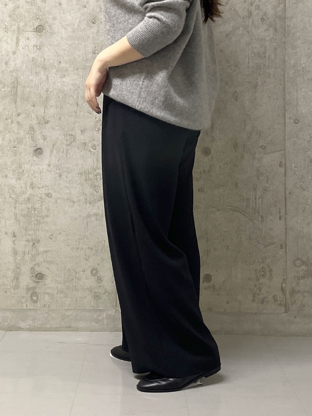 ブラック系のスラックス、グレー系のニット/セーター、ブラック系のローファーを着用したレディースの秋コーディネートの9枚目の写真