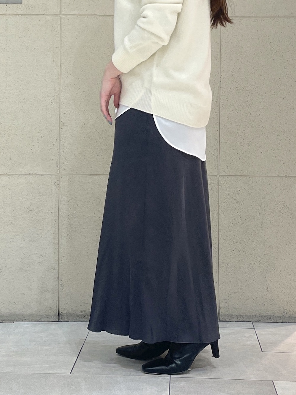 ホワイト系のニット/セーター、ホワイト系のシャツ/ブラウス、ブラック系のブーツを着用したレディースの冬コーディネートの9枚目の写真