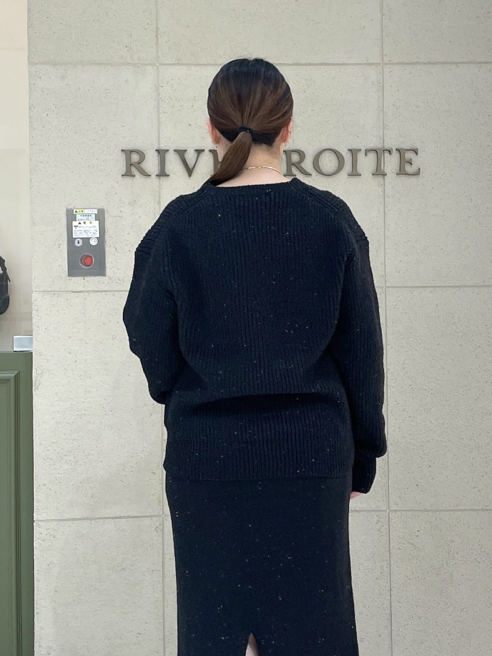 ブラック系のカーディガン/ボレロ、ブラック系のスカート、ブラウン系のボストンバッグを着用したレディースの秋コーディネートの6枚目の写真