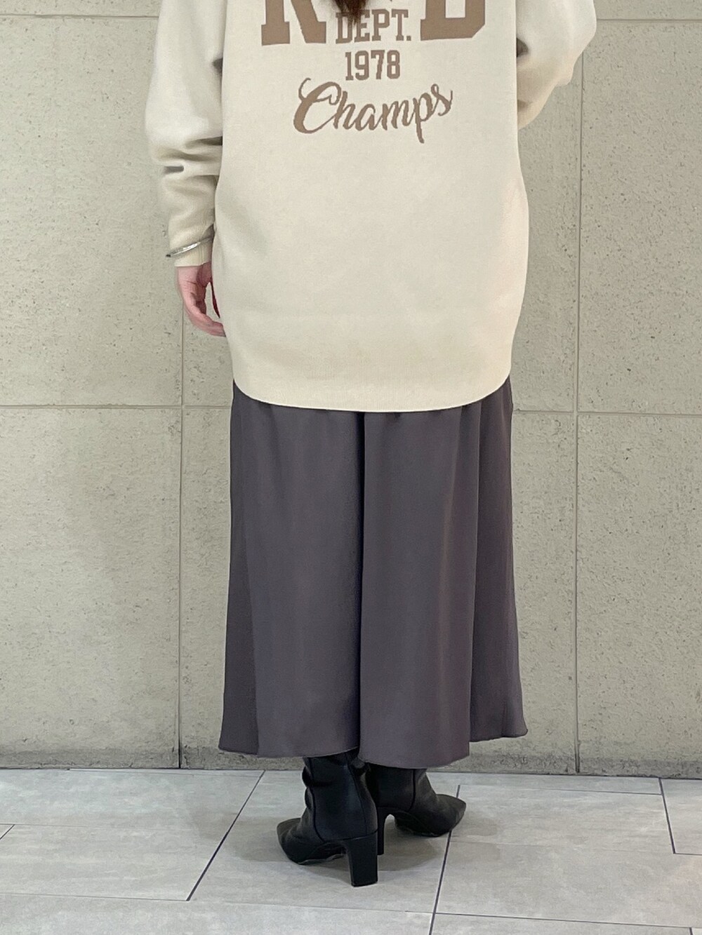 ホワイト系のニット/セーター、ホワイト系のTシャツ/カットソー、ブラウン系のスカートを着用したレディースの秋コーディネートの10枚目の写真