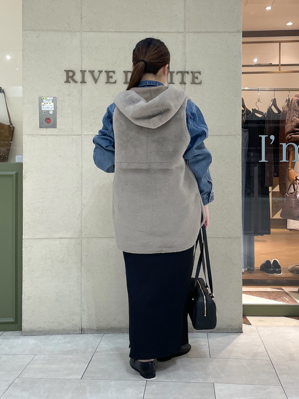 ブラック系のワンピース、ブラック系のローファー、ブラック系のショルダーバッグを着用したレディースの秋コーディネートの4枚目の写真