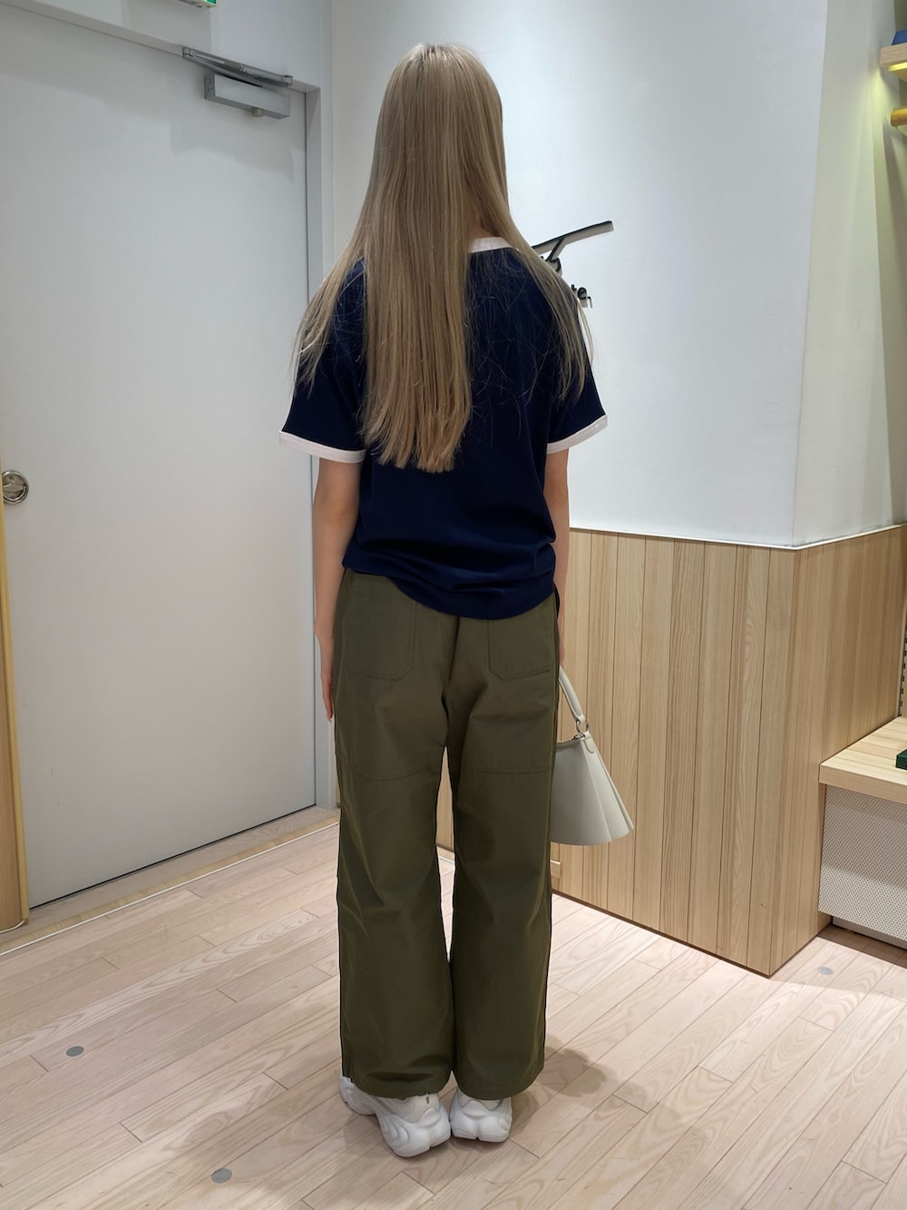 ブルー系のTシャツ/カットソー、グリーン系のカーゴパンツ、ホワイト系のスニーカーを着用したレディースの秋コーディネートの4枚目の写真