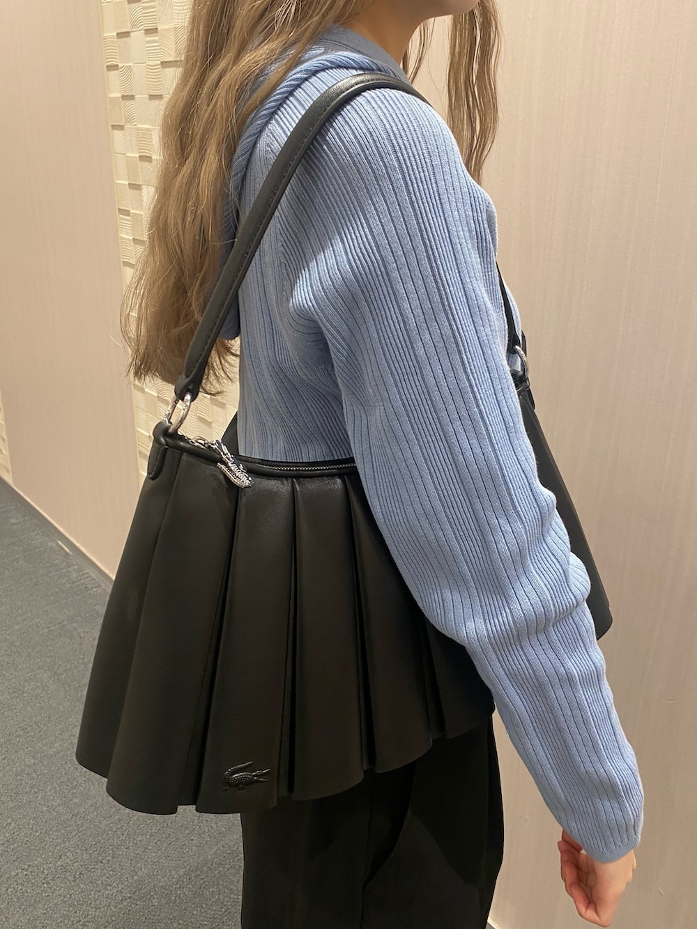 ブルー系のパーカー、ブラック系のステンカラーコート、ブラック系のスラックスを着用したレディースの冬コーディネートの5枚目の写真