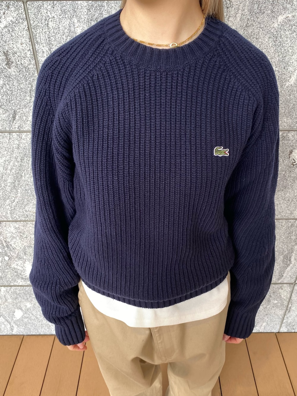 グリーン系のダウンジャケット/コート、ブルー系のニット/セーター、ベージュ系のチノパンツを着用したレディースの冬コーディネートの5枚目の写真