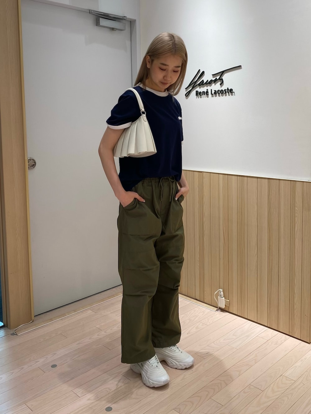 ブルー系のTシャツ/カットソー、グリーン系のカーゴパンツ、ホワイト系のスニーカーを着用したレディースの秋コーディネートの3枚目の写真