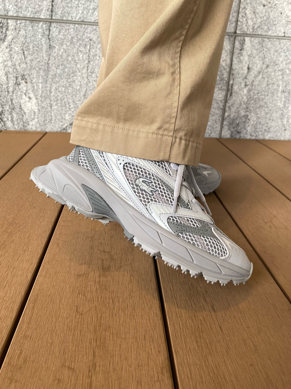 グリーン系のダウンジャケット/コート、ブルー系のニット/セーター、ベージュ系のチノパンツを着用したレディースの冬コーディネートの7枚目の写真