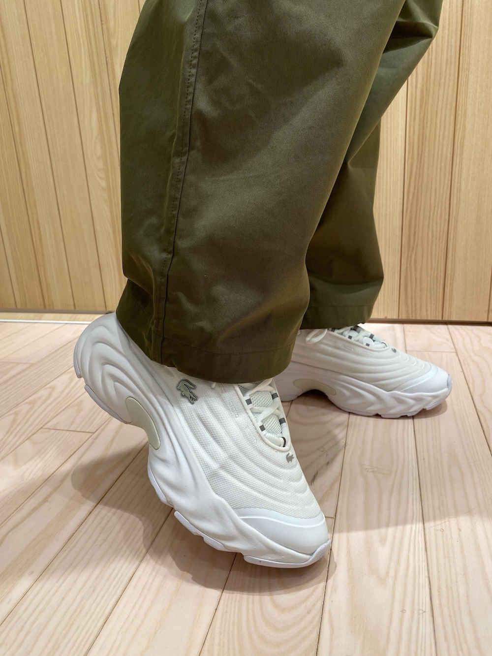 ブルー系のTシャツ/カットソー、グリーン系のカーゴパンツ、ホワイト系のスニーカーを着用したレディースの秋コーディネートの7枚目の写真