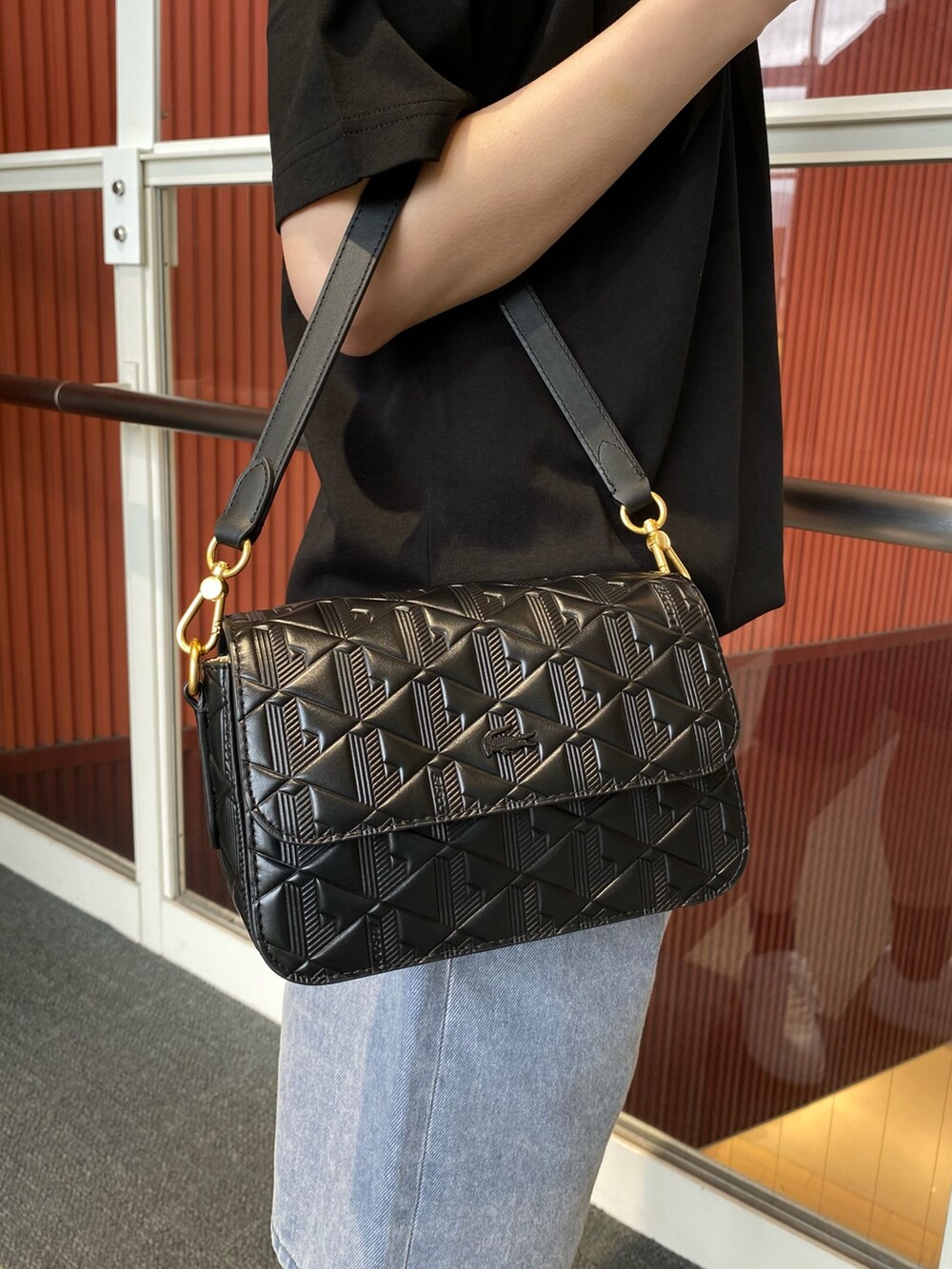 ブラック系のTシャツ/カットソー、グレー系のデニムパンツ、ブラック系のメッセンジャーバッグを着用したレディースの夏コーディネートの4枚目の写真