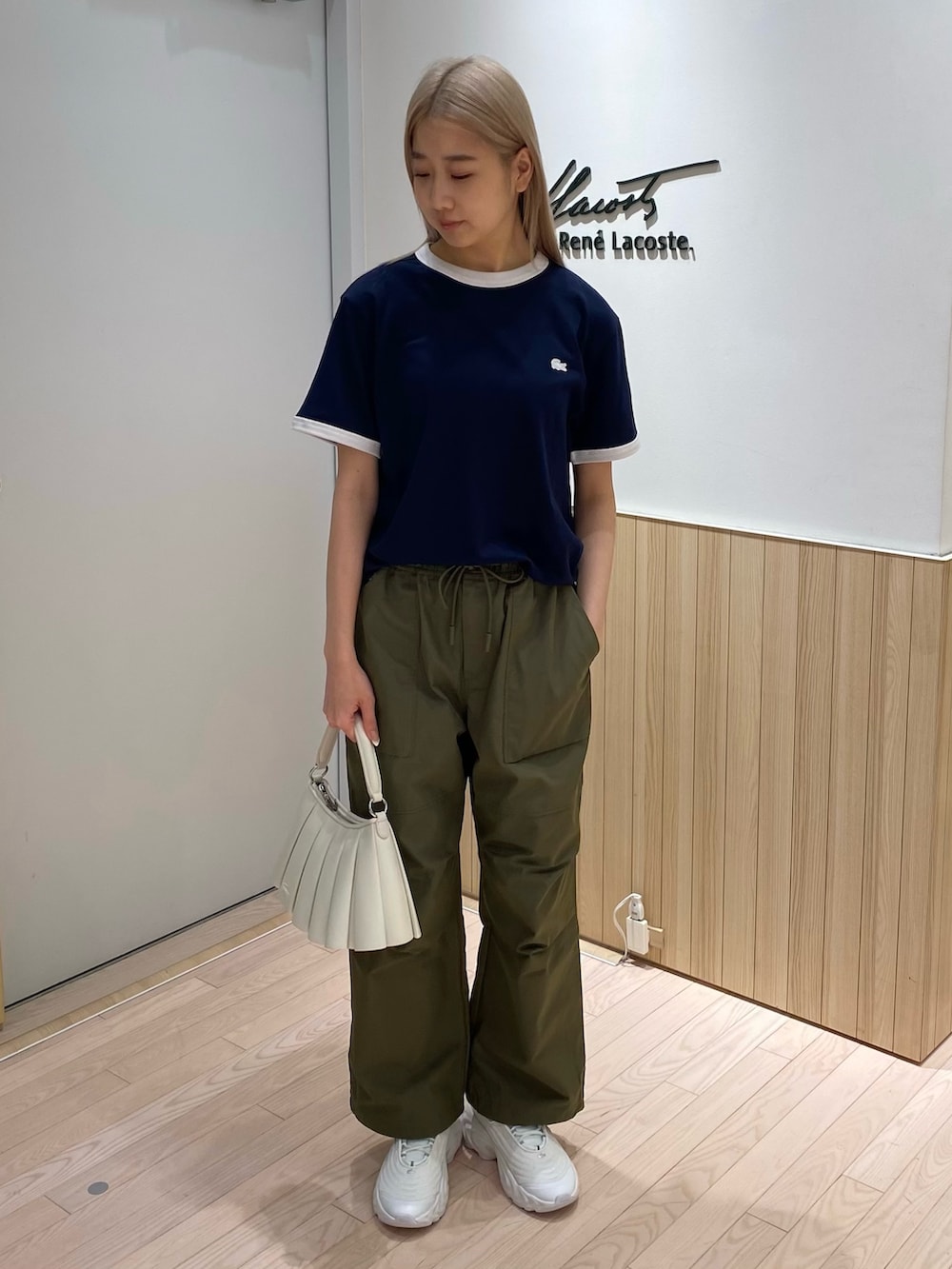 ブルー系のTシャツ/カットソー、グリーン系のカーゴパンツ、ホワイト系のスニーカーを着用したレディースの秋コーディネートの2枚目の写真