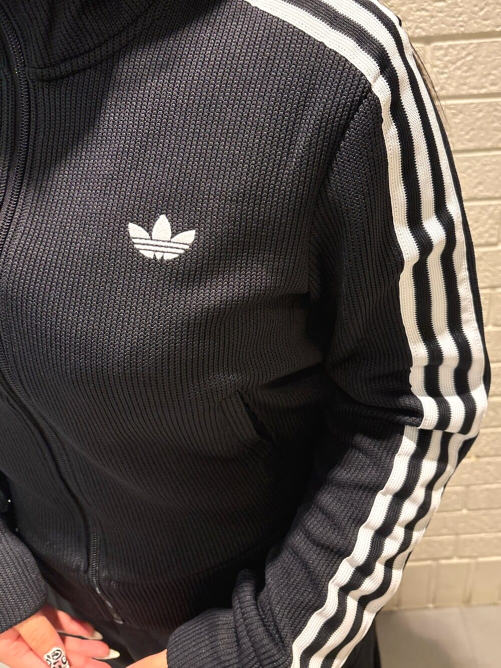 ブラック系のジャージ、レッド系のスニーカーを着用したレディースの秋コーディネートの3枚目の写真