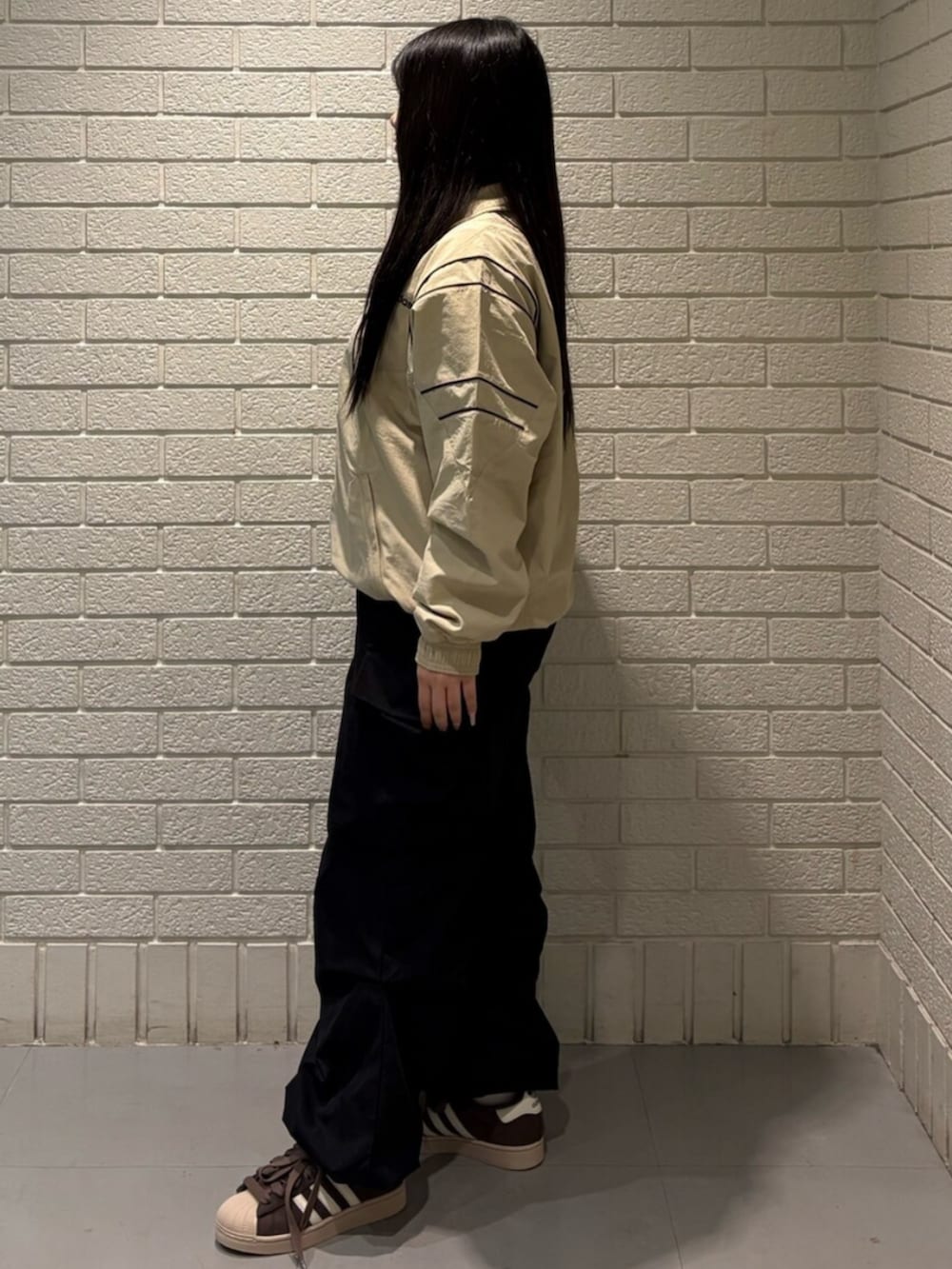 ベージュ系のジャージ、ブラウン系のスニーカーを着用したレディースの春コーディネートの2枚目の写真