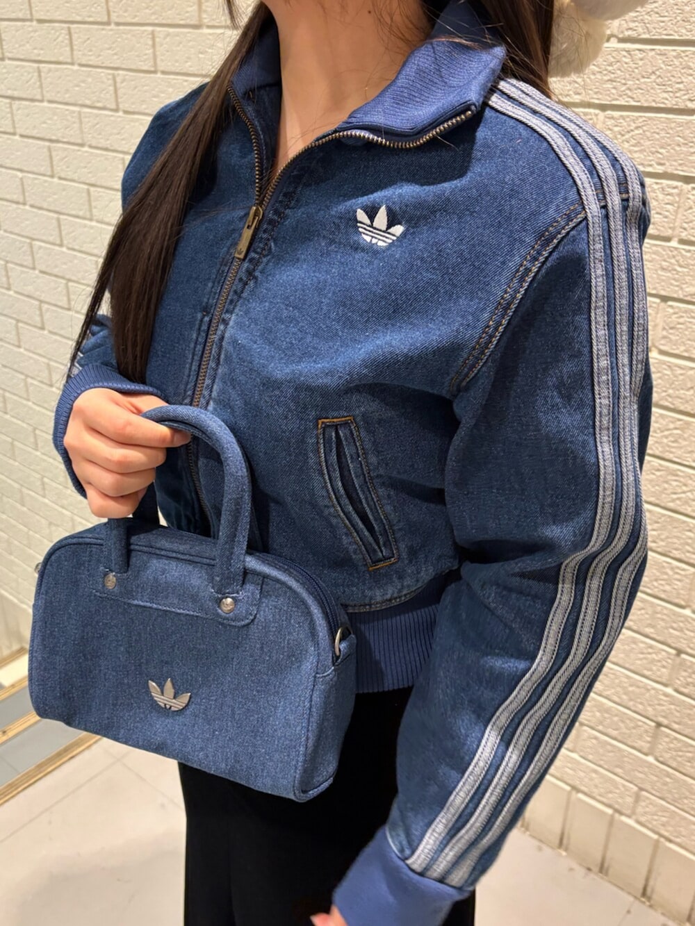 ブルー系のジャージ、ブルー系のスニーカー、ブルー系のショルダーバッグを着用したレディースの冬コーディネートの3枚目の写真