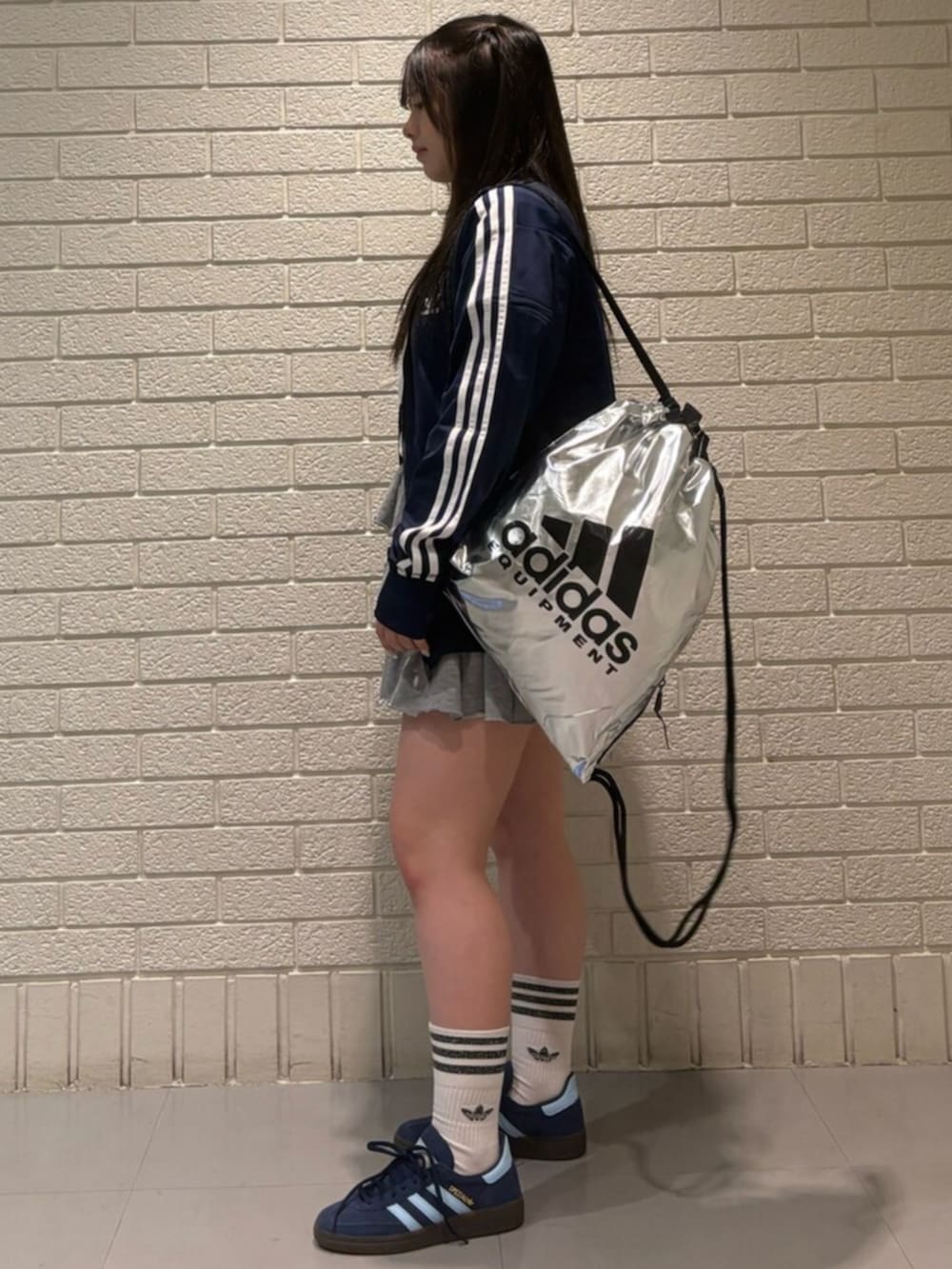 ブルー系のジャージ、ブルー系のスニーカー、シルバー系のバッグを着用したレディースの冬コーディネートの2枚目の写真