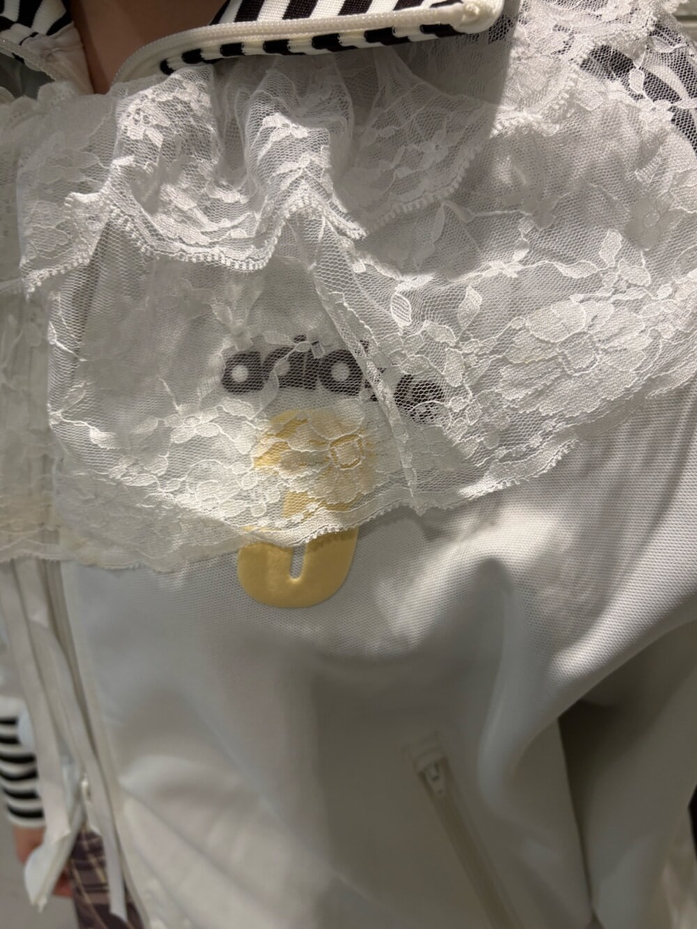 ホワイト系のジャージ、ブラック系のスニーカーを着用したレディースの冬コーディネートの3枚目の写真