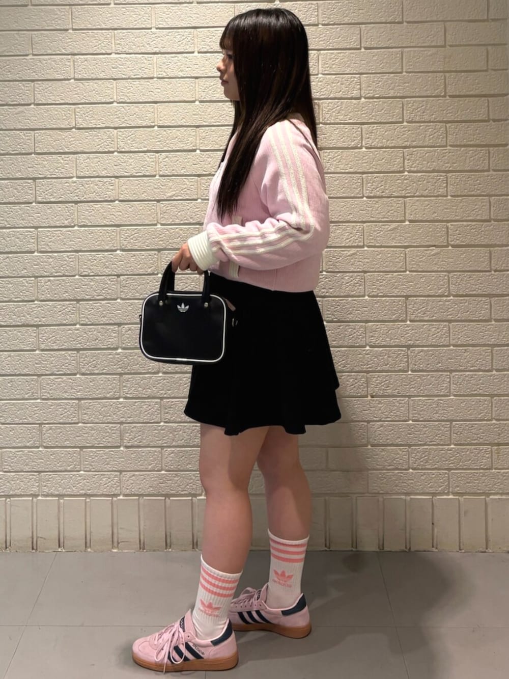 ピンク系のジャージ、ブラック系のショルダーバッグ、ピンク系のスニーカーを着用したレディースの秋コーディネートの2枚目の写真