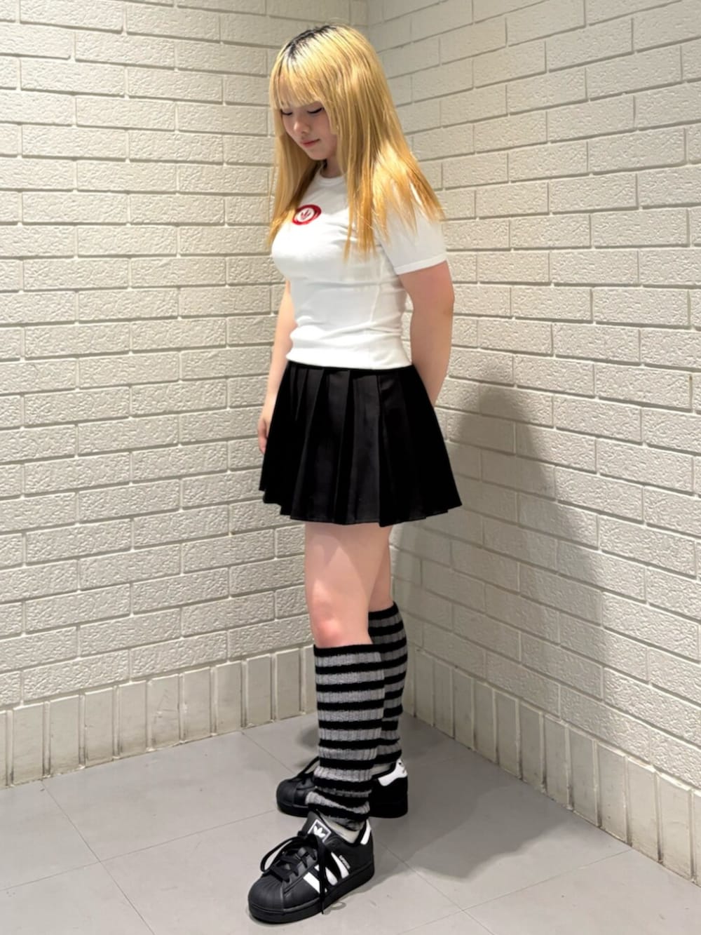 ホワイト系のTシャツ/カットソー、ブラック系のスニーカーを着用したレディースの春コーディネートの2枚目の写真