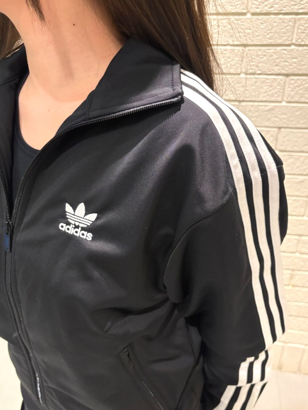 ブラック系のトップス、イエロー系のスニーカーを着用したレディースの秋コーディネートの3枚目の写真