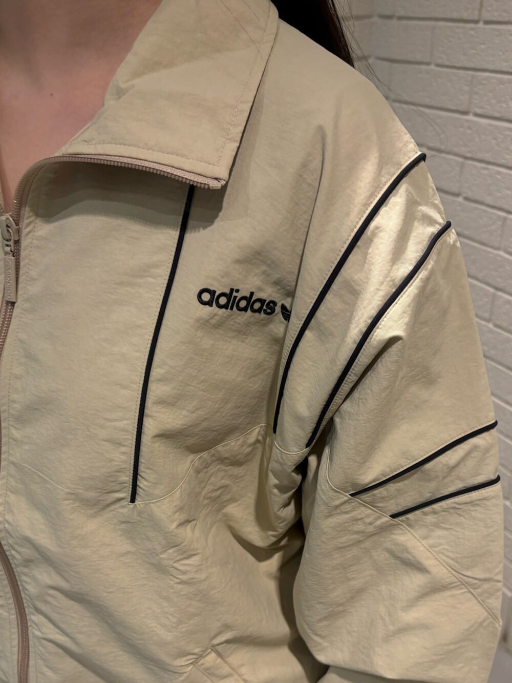 ベージュ系のジャージ、ブラウン系のスニーカーを着用したレディースの春コーディネートの3枚目の写真