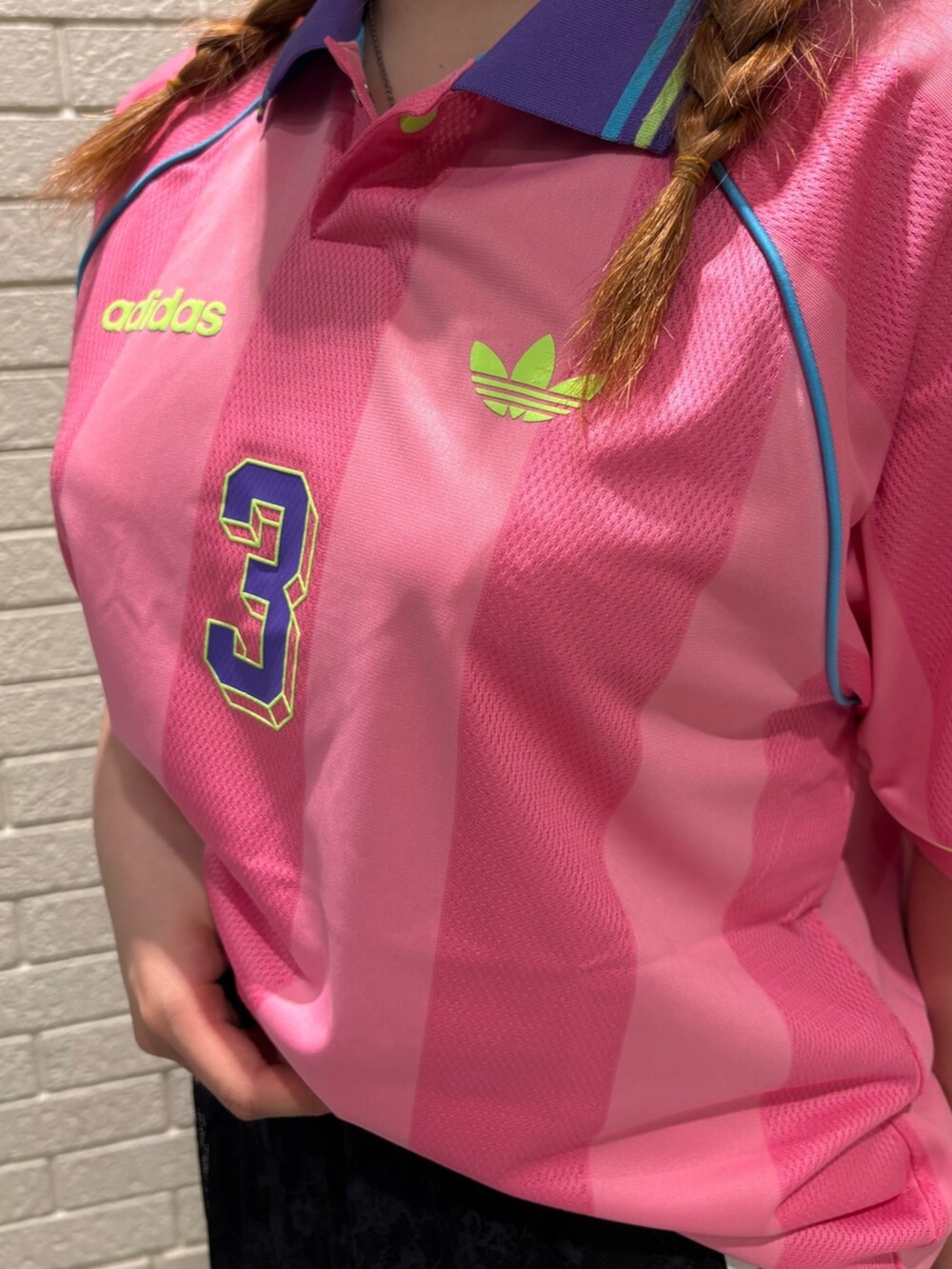 ピンク系のTシャツ/カットソー、ブラック系のスカート、ホワイト系のシューズを着用したレディースの夏コーディネートの3枚目の写真