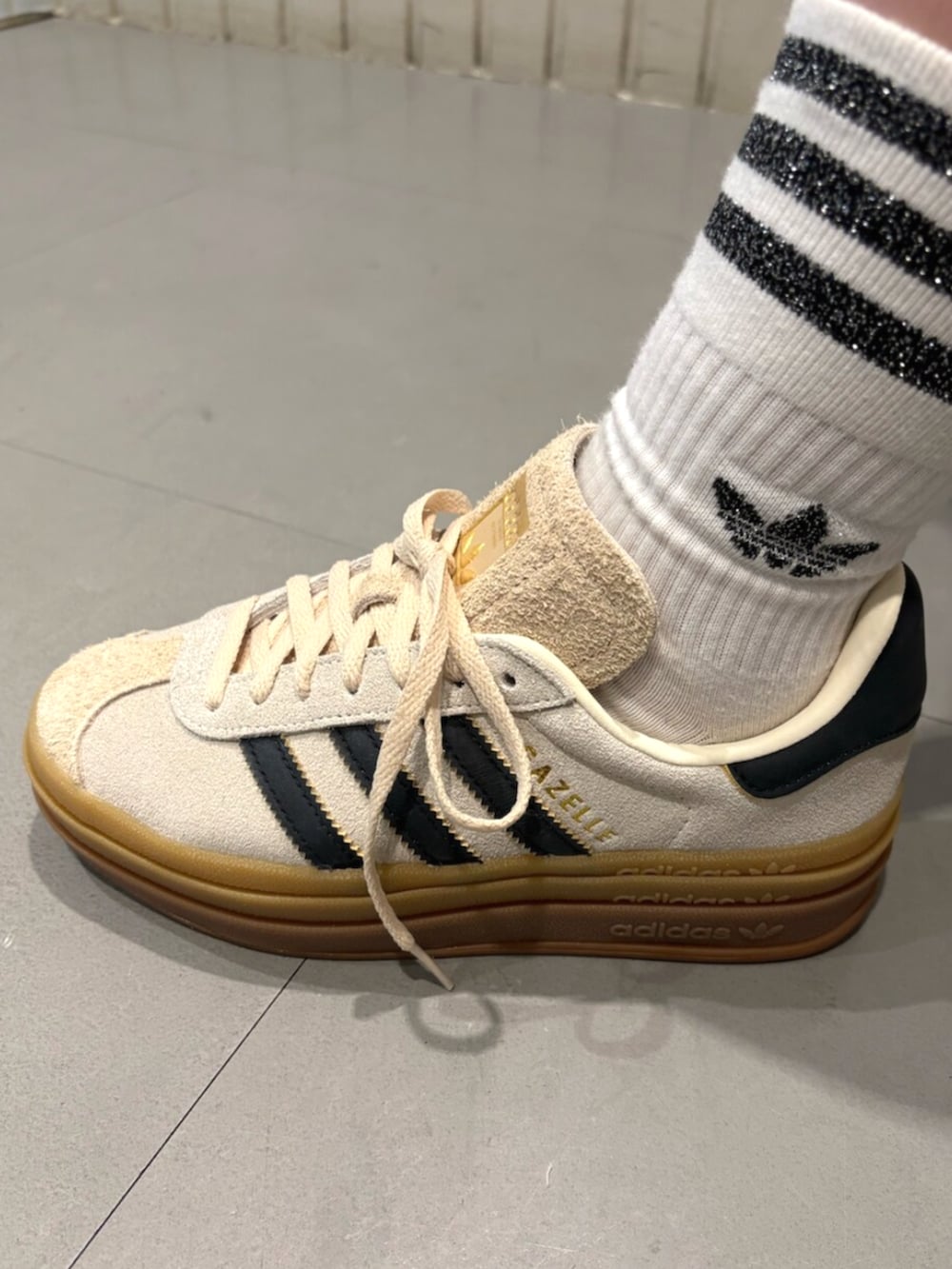 ホワイト系のスニーカー、ブラック系のデニムジャケット、ブルー系のスウェットパンツを着用したレディースの夏コーディネートの4枚目の写真