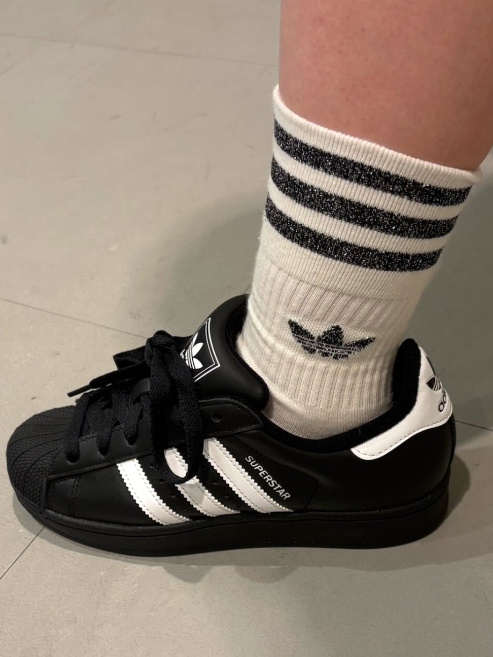 ブラック系のスニーカー、ホワイト系のジャージ、ホワイト系のソックス/靴下を着用したレディースの秋コーディネートの4枚目の写真