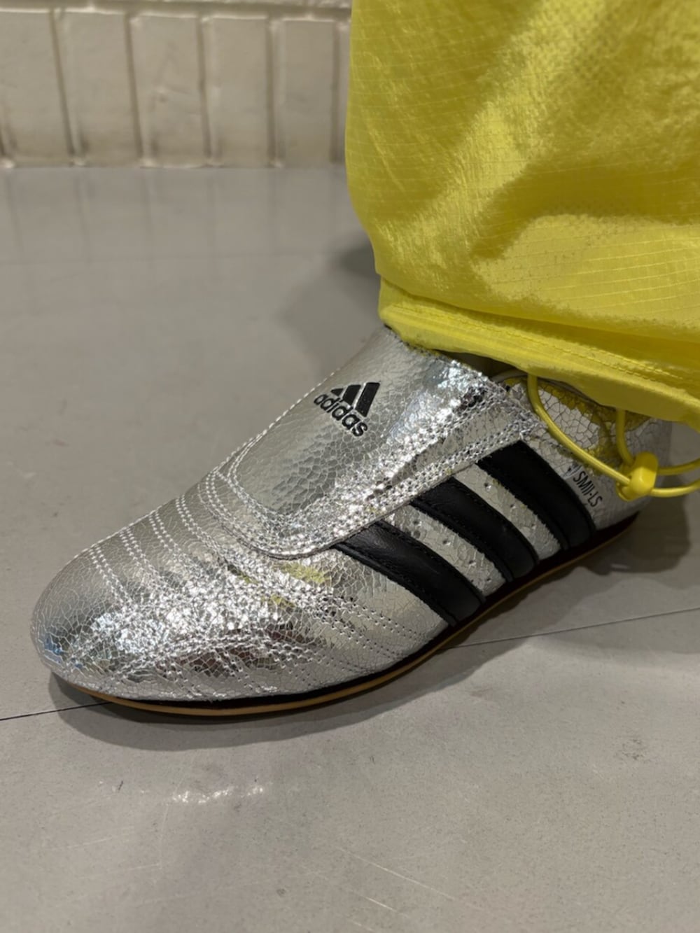 ホワイト系のTシャツ/カットソー、シルバー系のシューズ、イエロー系のパンツを着用したレディースの春コーディネートの4枚目の写真