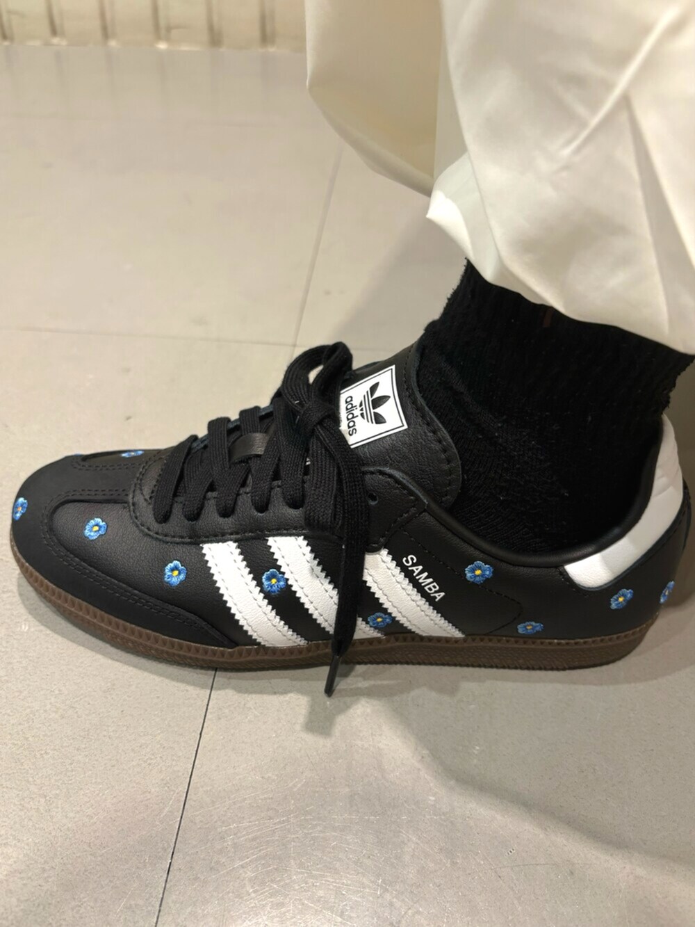 ブラック系のジャージ、ホワイト系のスカート、ブラック系のスニーカーを着用したレディースの冬コーディネートの4枚目の写真