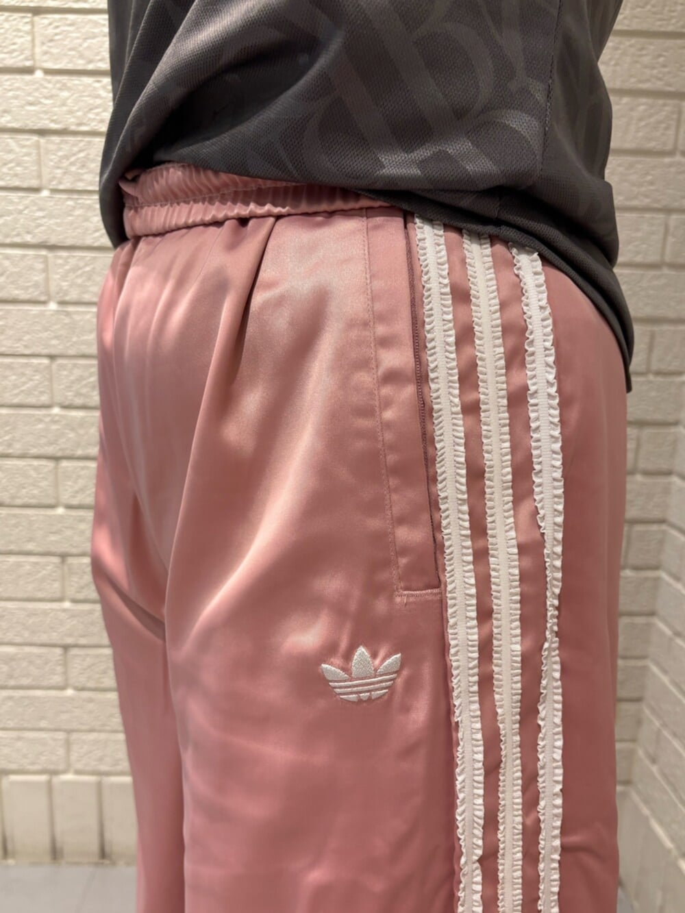 ブラウン系のトップス、ピンク系のスウェットパンツ、ホワイト系のスニーカーを着用したレディースの夏コーディネートの3枚目の写真