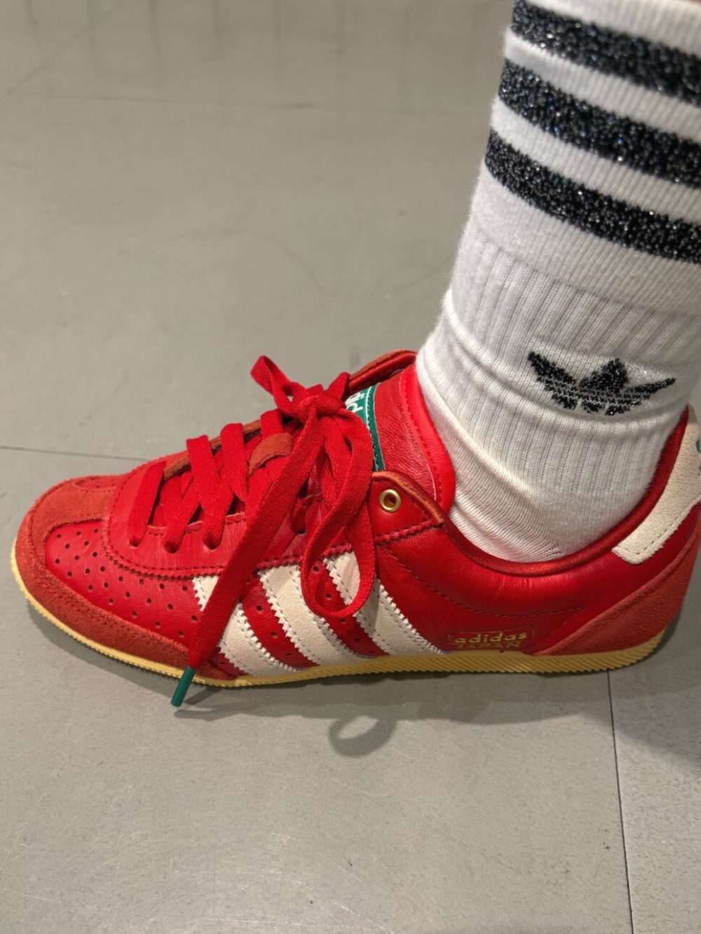 レッド系のスニーカー、ブルー系のジャージ、ホワイト系のその他パンツを着用したレディースの夏コーディネートの4枚目の写真