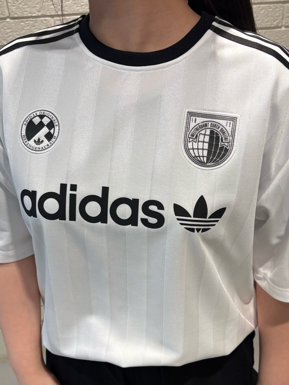 ブラック系のシューズ、ホワイト系のトップスを着用したレディースの春コーディネートの3枚目の写真