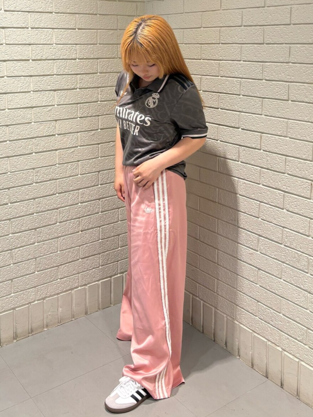 ブラウン系のトップス、ピンク系のスウェットパンツ、ホワイト系のスニーカーを着用したレディースの夏コーディネートの2枚目の写真