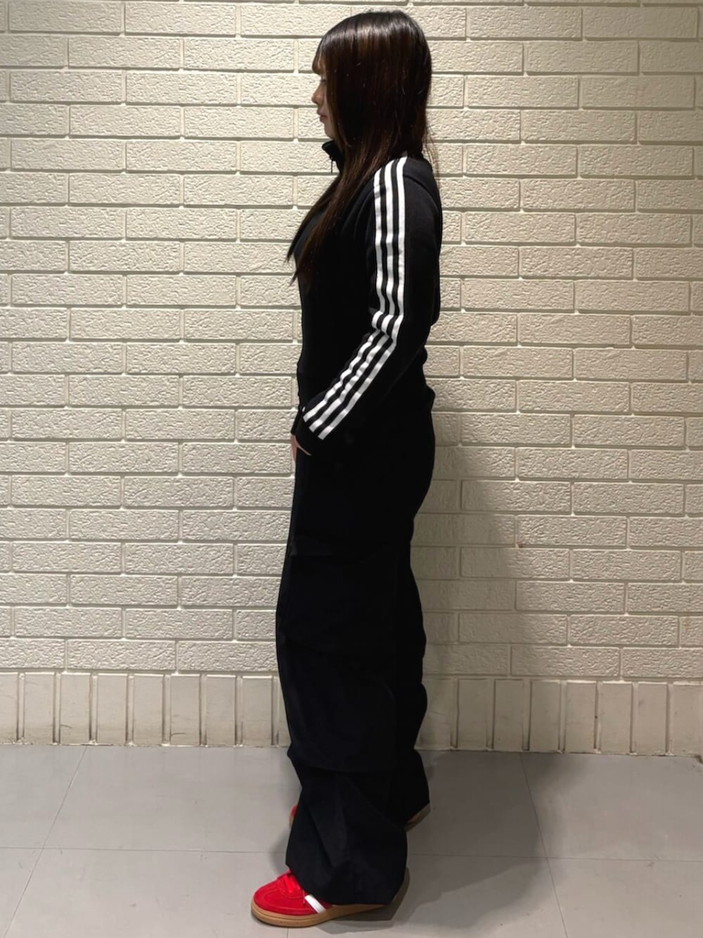 ブラック系のジャージ、レッド系のスニーカーを着用したレディースの秋コーディネートの2枚目の写真