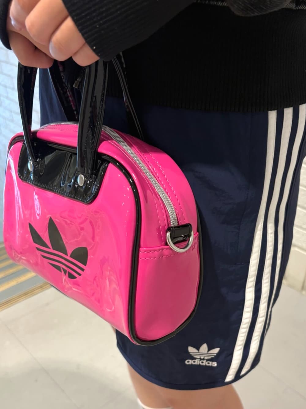 ホワイト系のスニーカー、ブラック系のデニムジャケット、ブルー系のスウェットパンツを着用したレディースの夏コーディネートの3枚目の写真