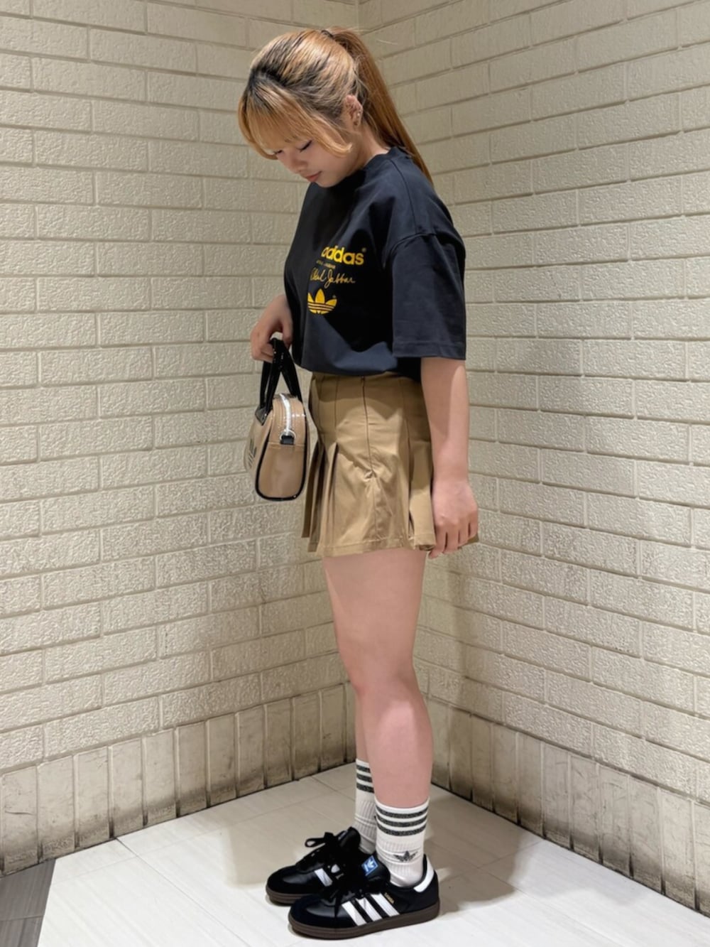 ベージュ系のスカート、グレー系のTシャツ/カットソー、ベージュ系のショルダーバッグを着用したレディースの夏コーディネートの2枚目の写真