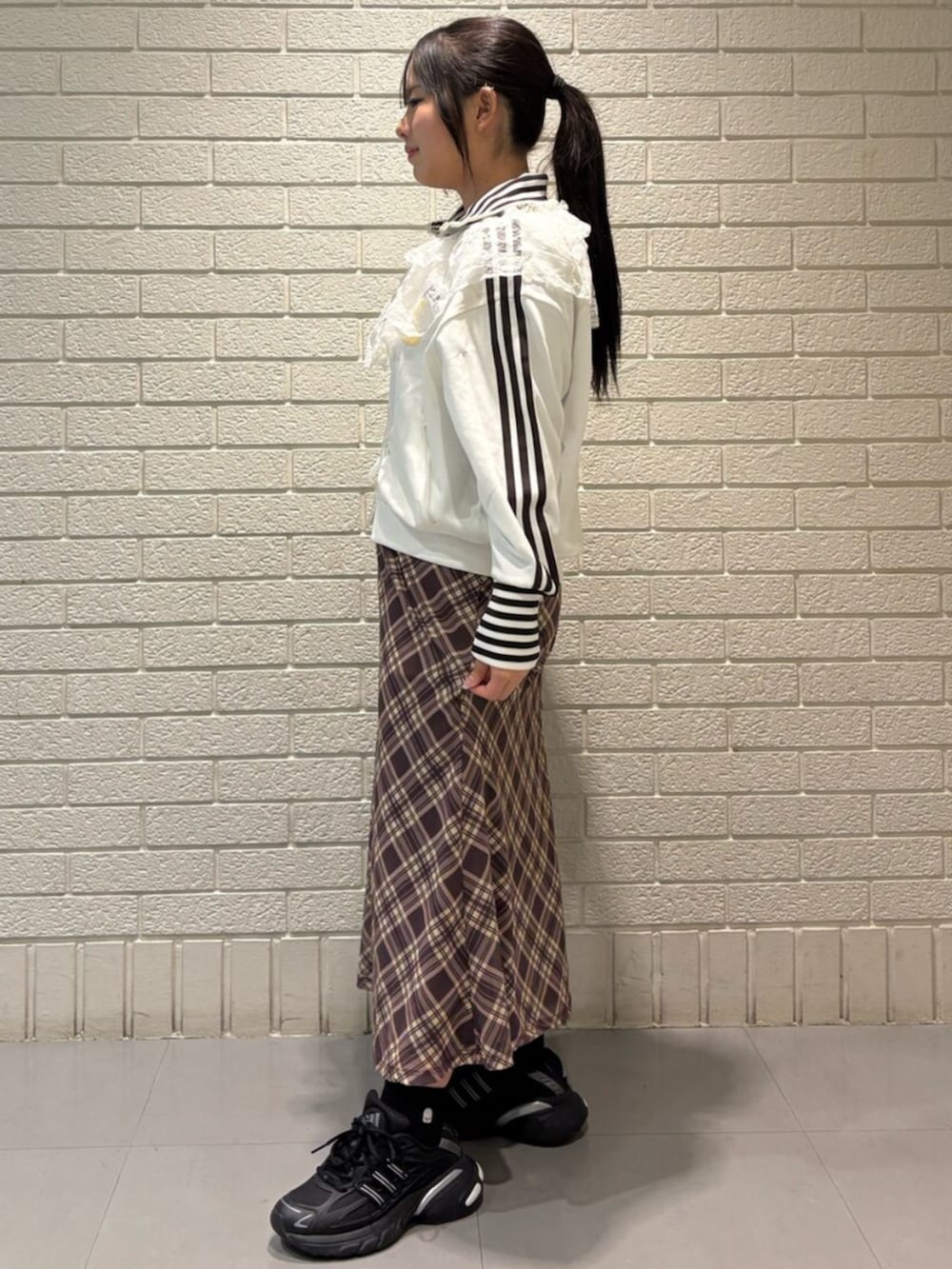 ホワイト系のジャージ、ブラック系のスニーカーを着用したレディースの冬コーディネートの2枚目の写真