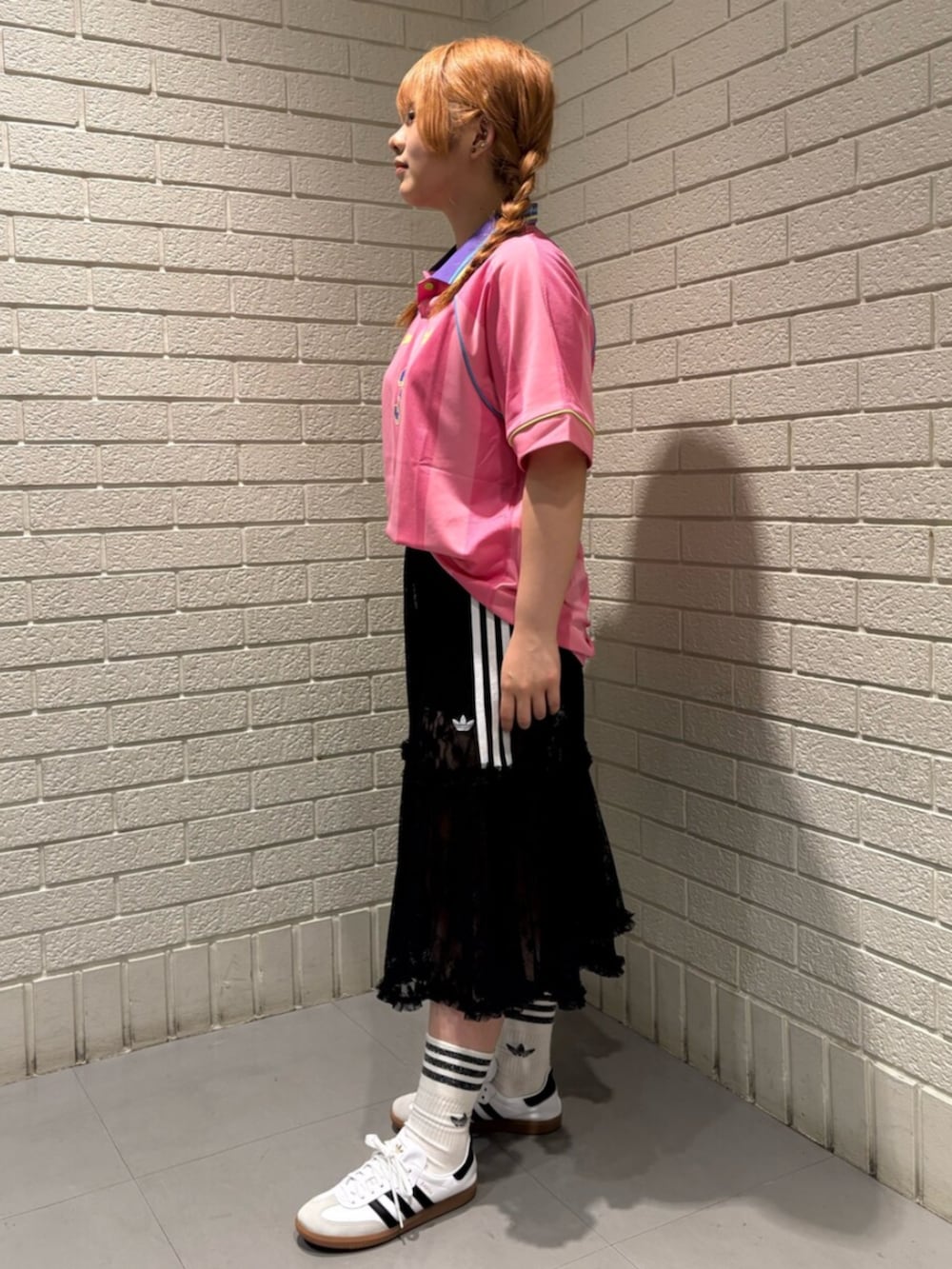 ピンク系のTシャツ/カットソー、ブラック系のスカート、ホワイト系のシューズを着用したレディースの夏コーディネートの2枚目の写真