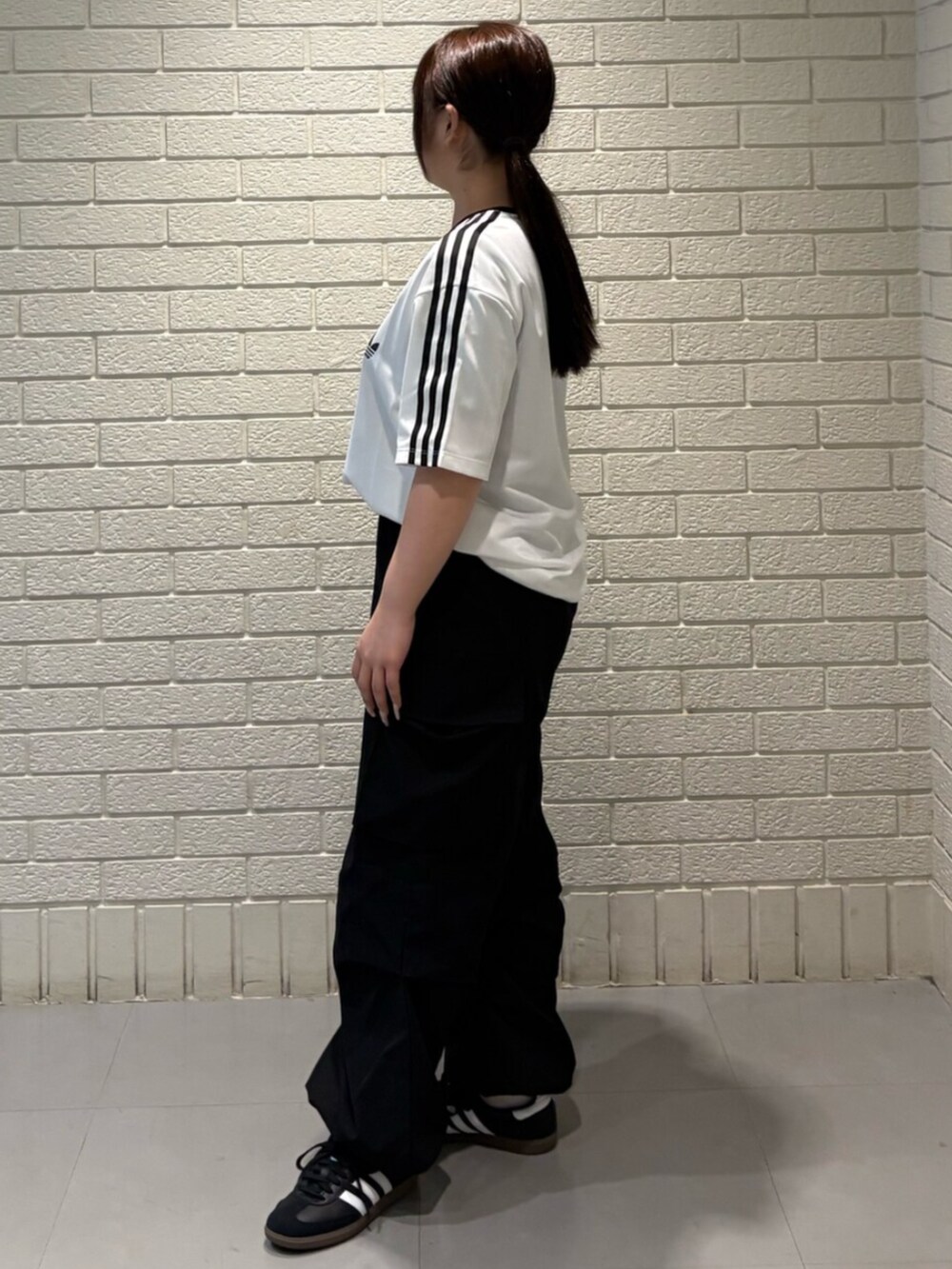 ブラック系のシューズ、ホワイト系のトップスを着用したレディースの春コーディネートの2枚目の写真