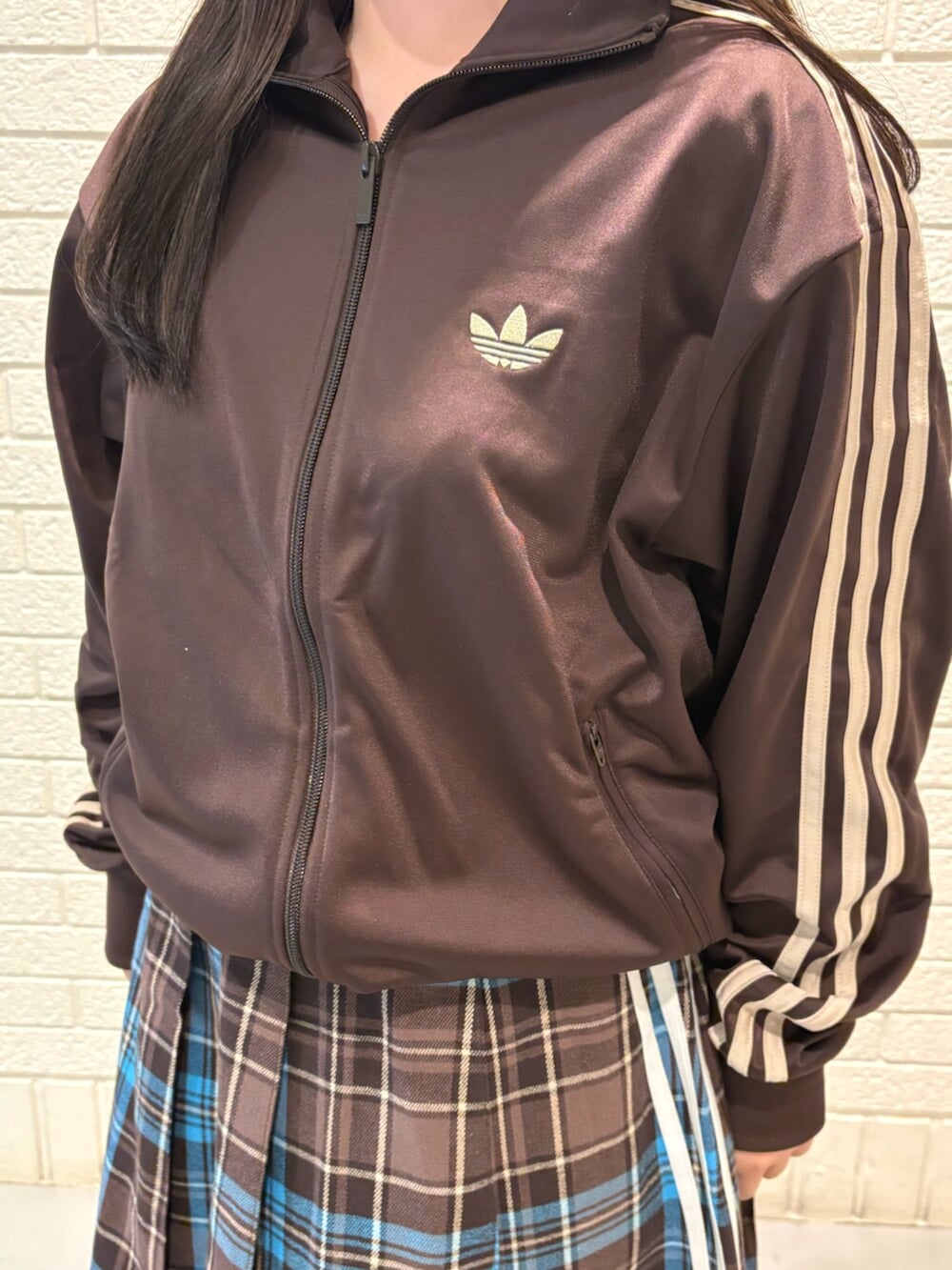 ブラウン系のスカート、ブラウン系のトップス、ホワイト系のスニーカーを着用したレディースの春コーディネートの3枚目の写真