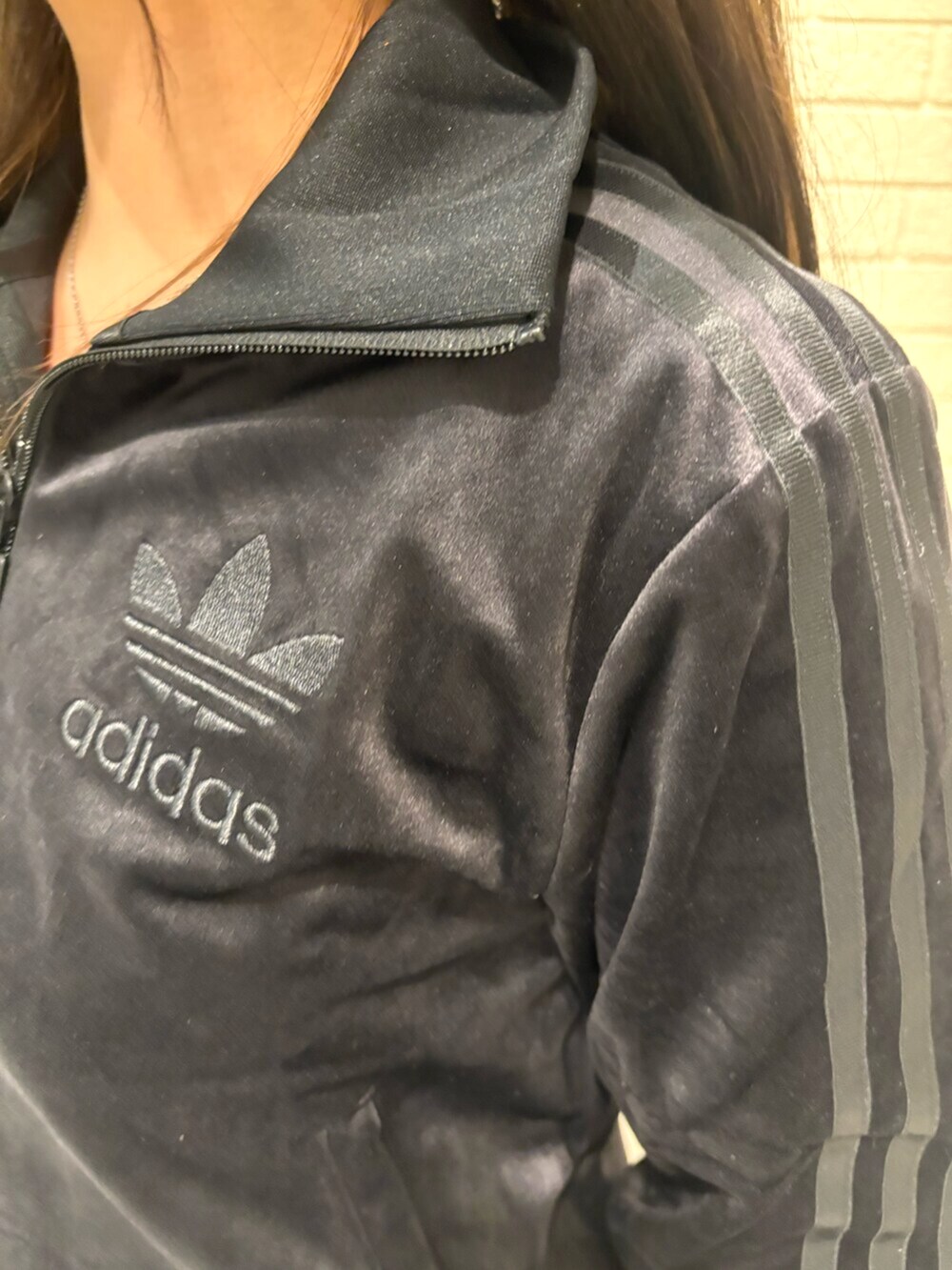 ブラック系のジャージ、ホワイト系のスカート、ブラック系のスニーカーを着用したレディースの冬コーディネートの3枚目の写真