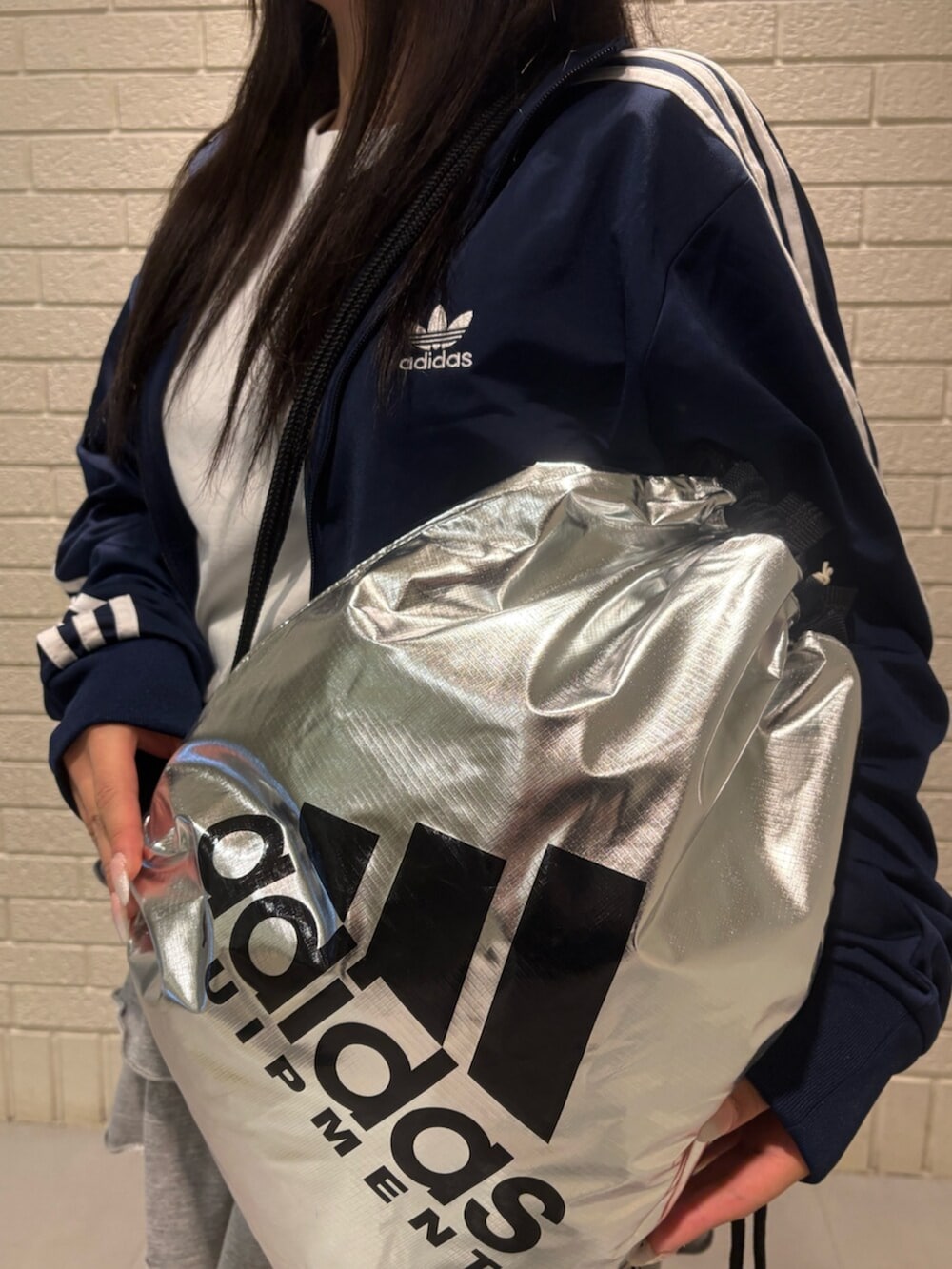 ブルー系のジャージ、ブルー系のスニーカー、シルバー系のバッグを着用したレディースの冬コーディネートの3枚目の写真