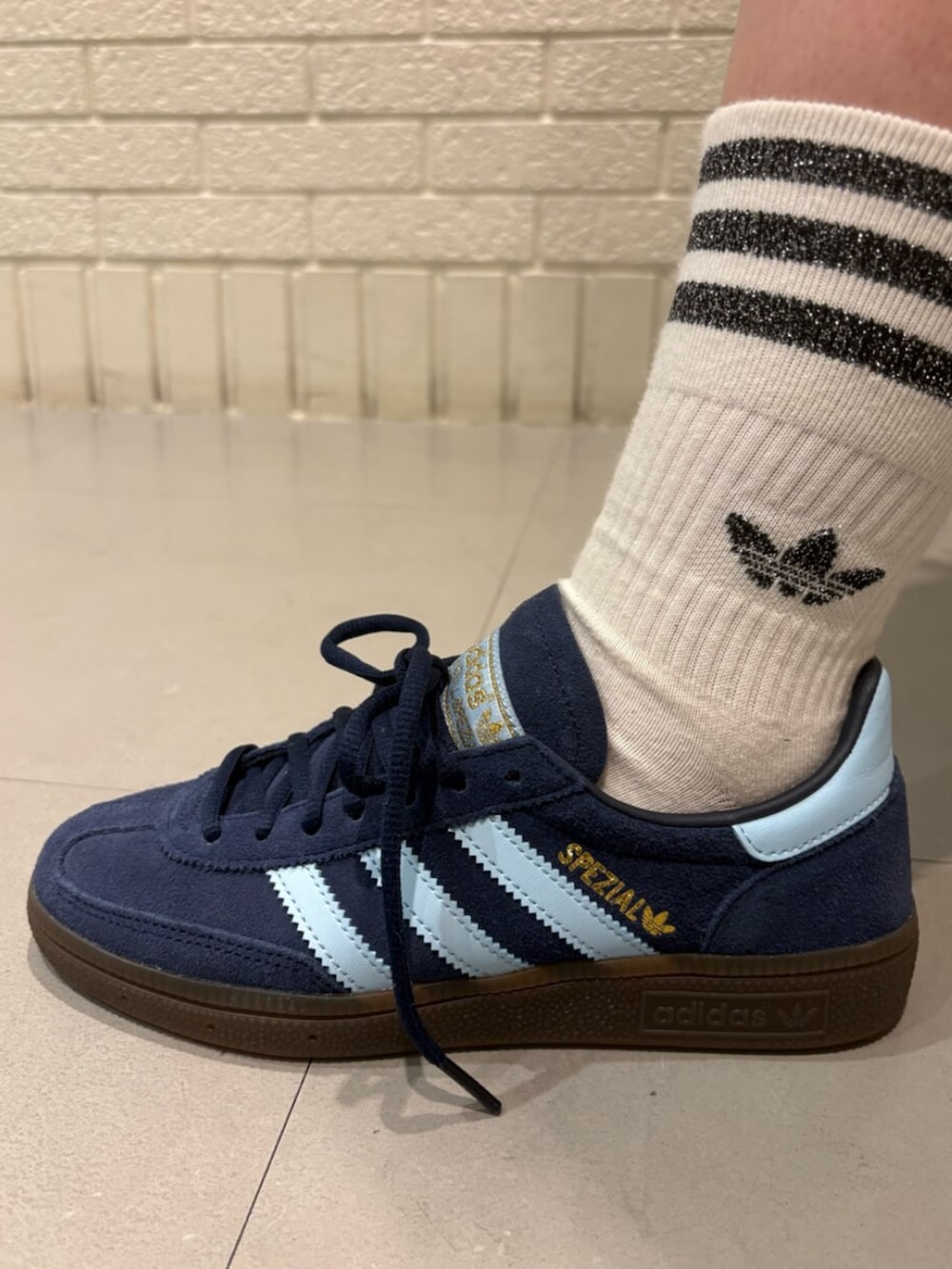 ブルー系のジャージ、ブルー系のスニーカー、シルバー系のバッグを着用したレディースの冬コーディネートの4枚目の写真