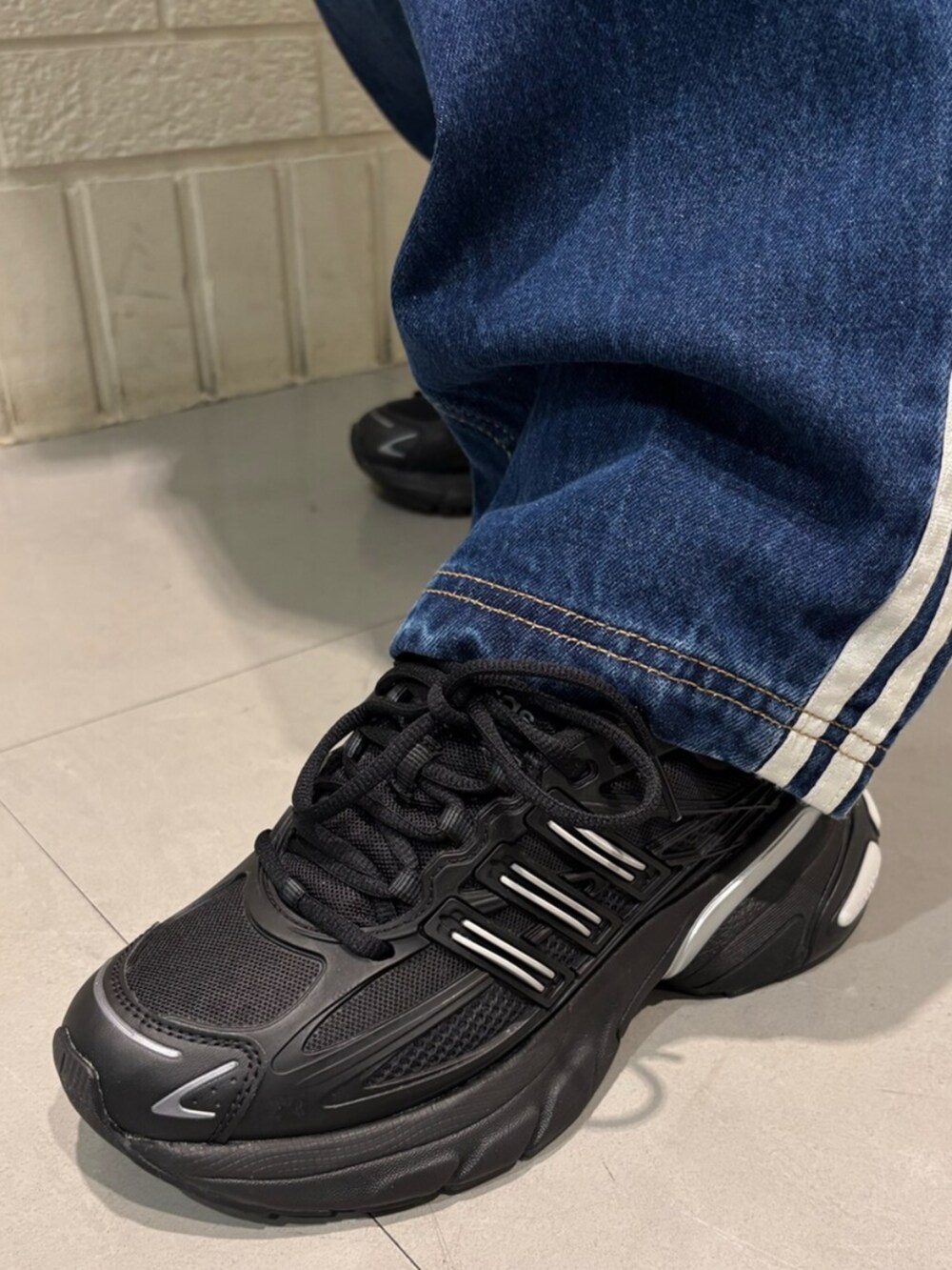 ブラック系のスニーカー、ブラウン系のトップスを着用したレディースの冬コーディネートの4枚目の写真