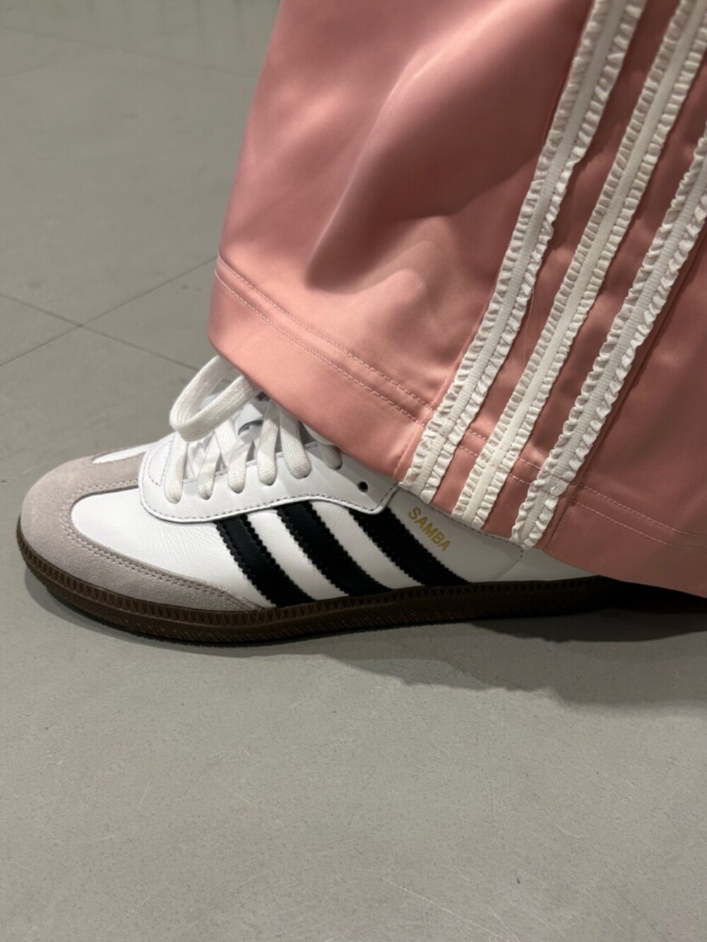 ブラウン系のトップス、ピンク系のスウェットパンツ、ホワイト系のスニーカーを着用したレディースの夏コーディネートの4枚目の写真