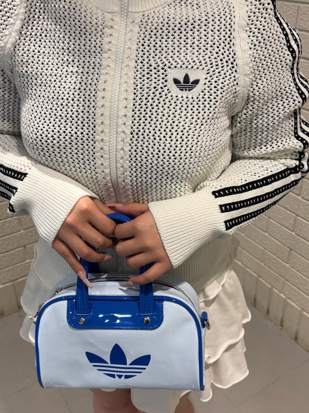 ブルー系のスニーカー、ホワイト系のジャージを着用したレディースの春コーディネートの2枚目の写真