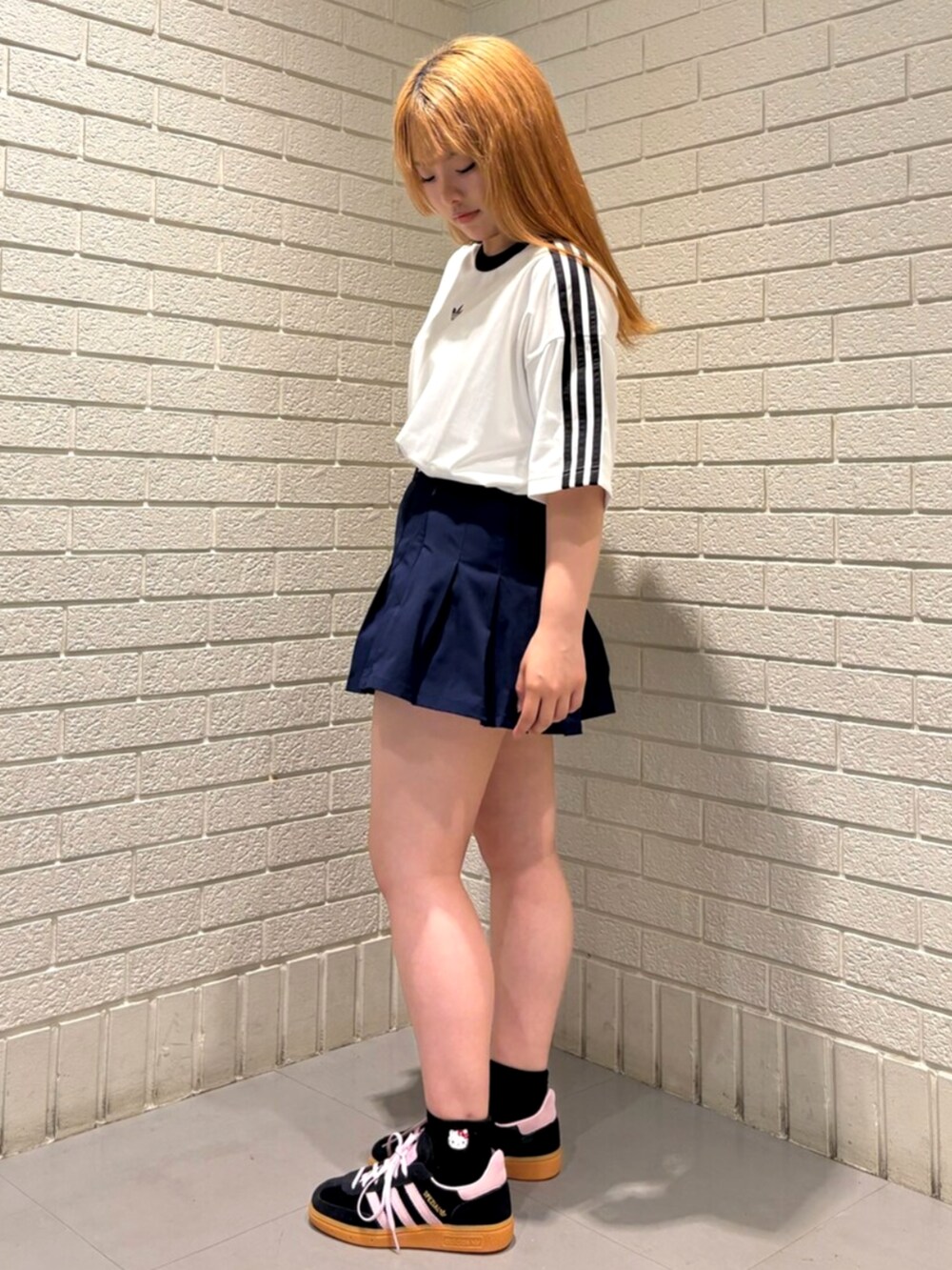 ホワイト系のTシャツ/カットソー、ブルー系のスカート、ブラック系のスニーカーを着用したレディースの夏コーディネートの2枚目の写真