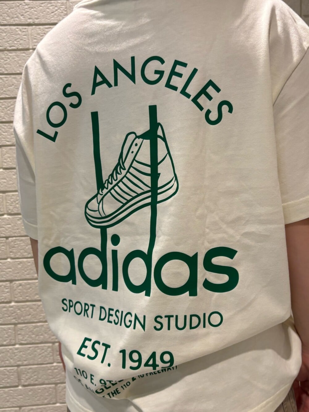ホワイト系のTシャツ/カットソー、グリーン系のパンツ、ブルー系のスニーカーを着用したレディースの春コーディネートの3枚目の写真