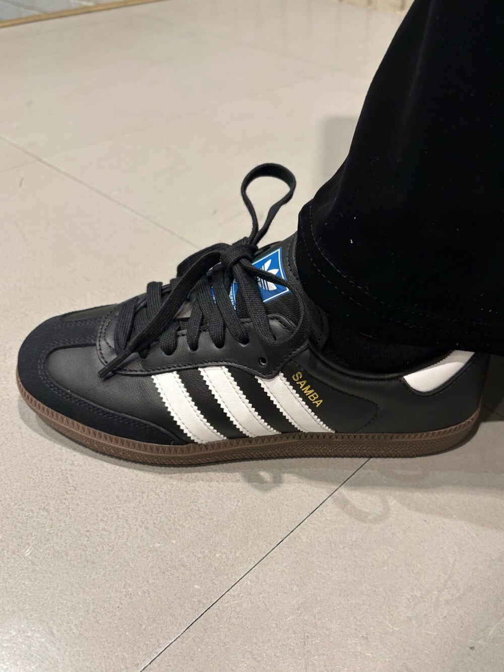 ホワイト系のジャージ、ブルー系のショルダーバッグを着用したレディースの冬コーディネートの4枚目の写真