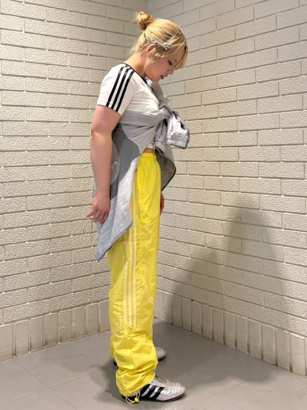 ホワイト系のTシャツ/カットソー、シルバー系のシューズ、イエロー系のパンツを着用したレディースの春コーディネートの2枚目の写真
