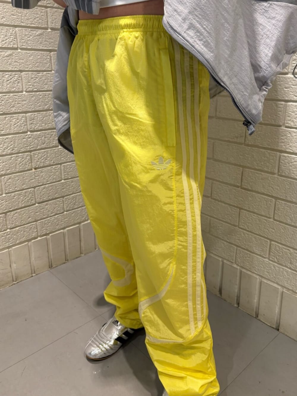 ホワイト系のTシャツ/カットソー、シルバー系のシューズ、イエロー系のパンツを着用したレディースの春コーディネートの3枚目の写真