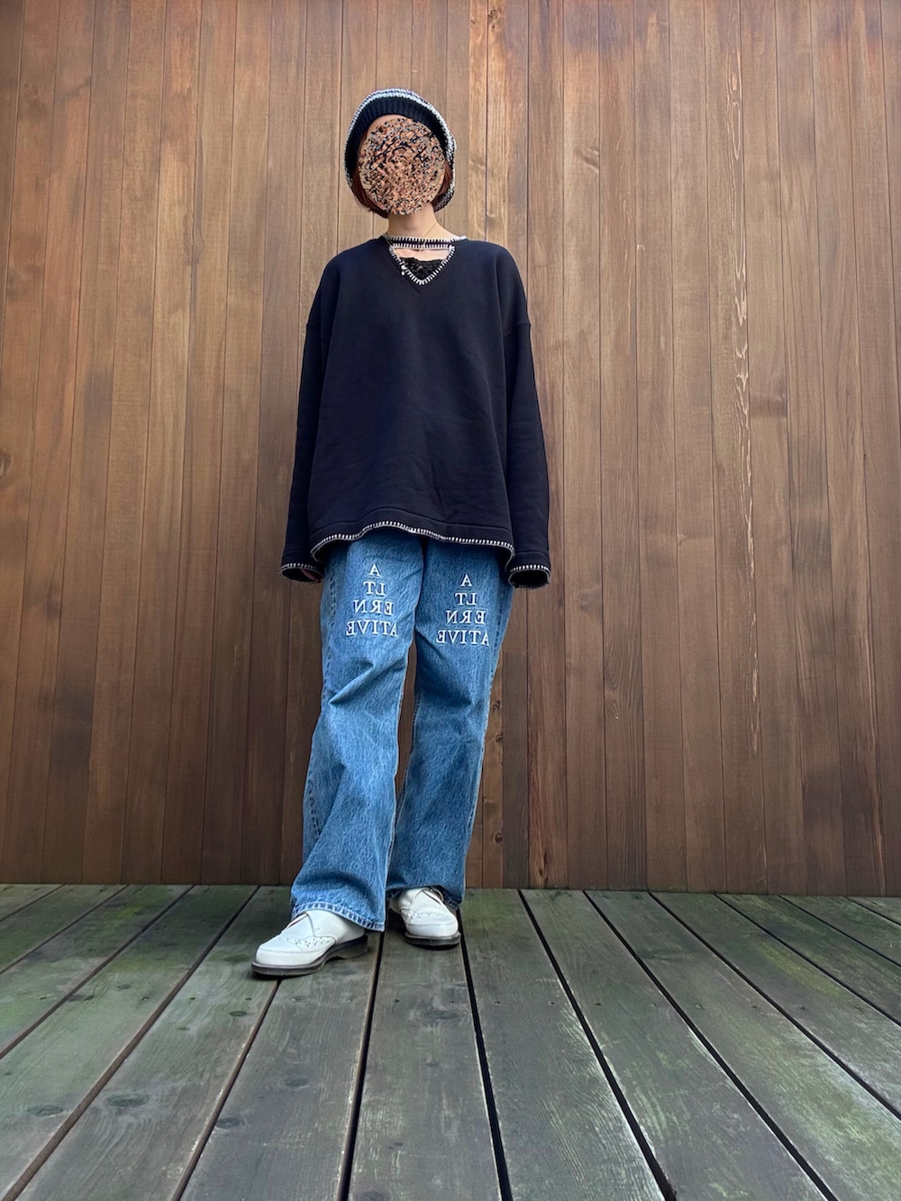 ブラック系のTシャツ/カットソー、ブルー系のデニムパンツ、ブラック系のニットキャップ/ビーニーを着用したレディースの秋コーディネートの2枚目の写真